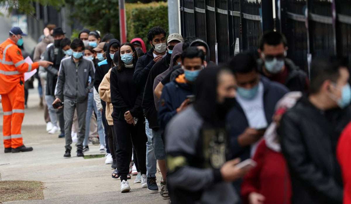 People wait in line outside a coronavirus vaccination clinic in Sydney